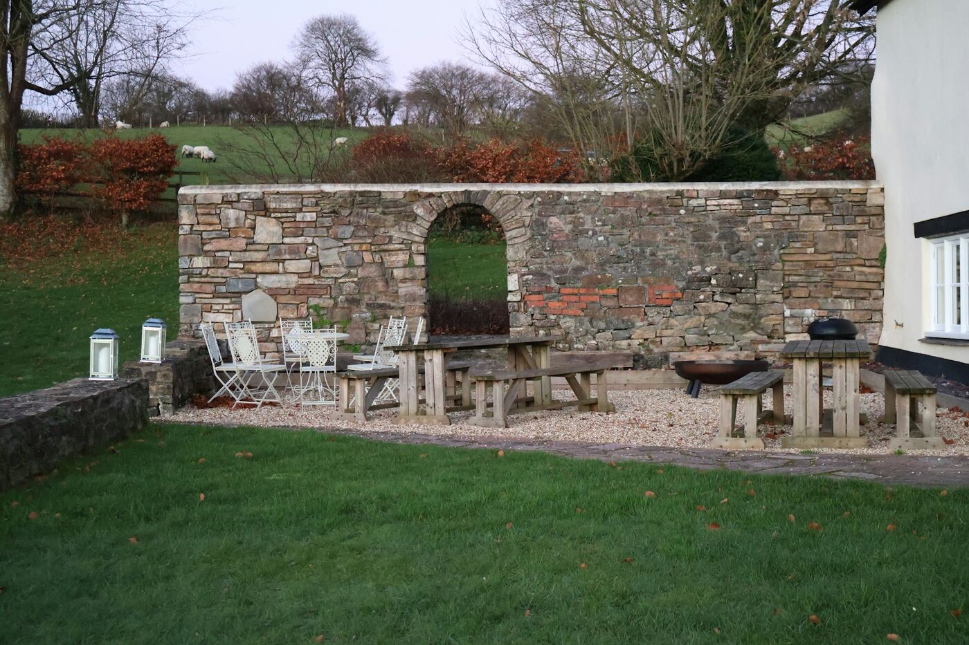 Fertiggestellter Sitzplatz mit Natursteinmauer und gepflegter Rasenfläche nach der Übergabe